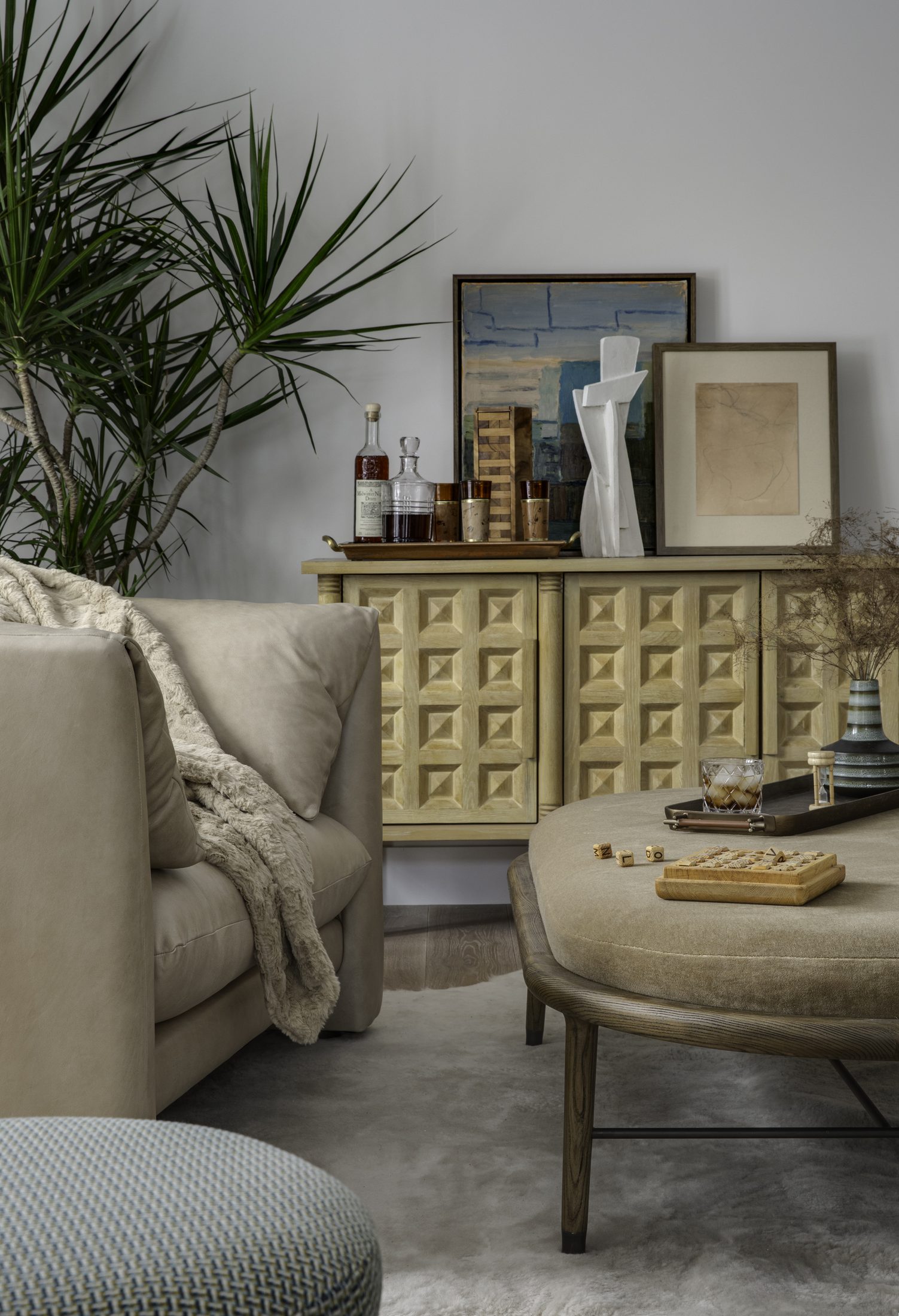 Sitting area with an ochre carved cabinet and shearling throw