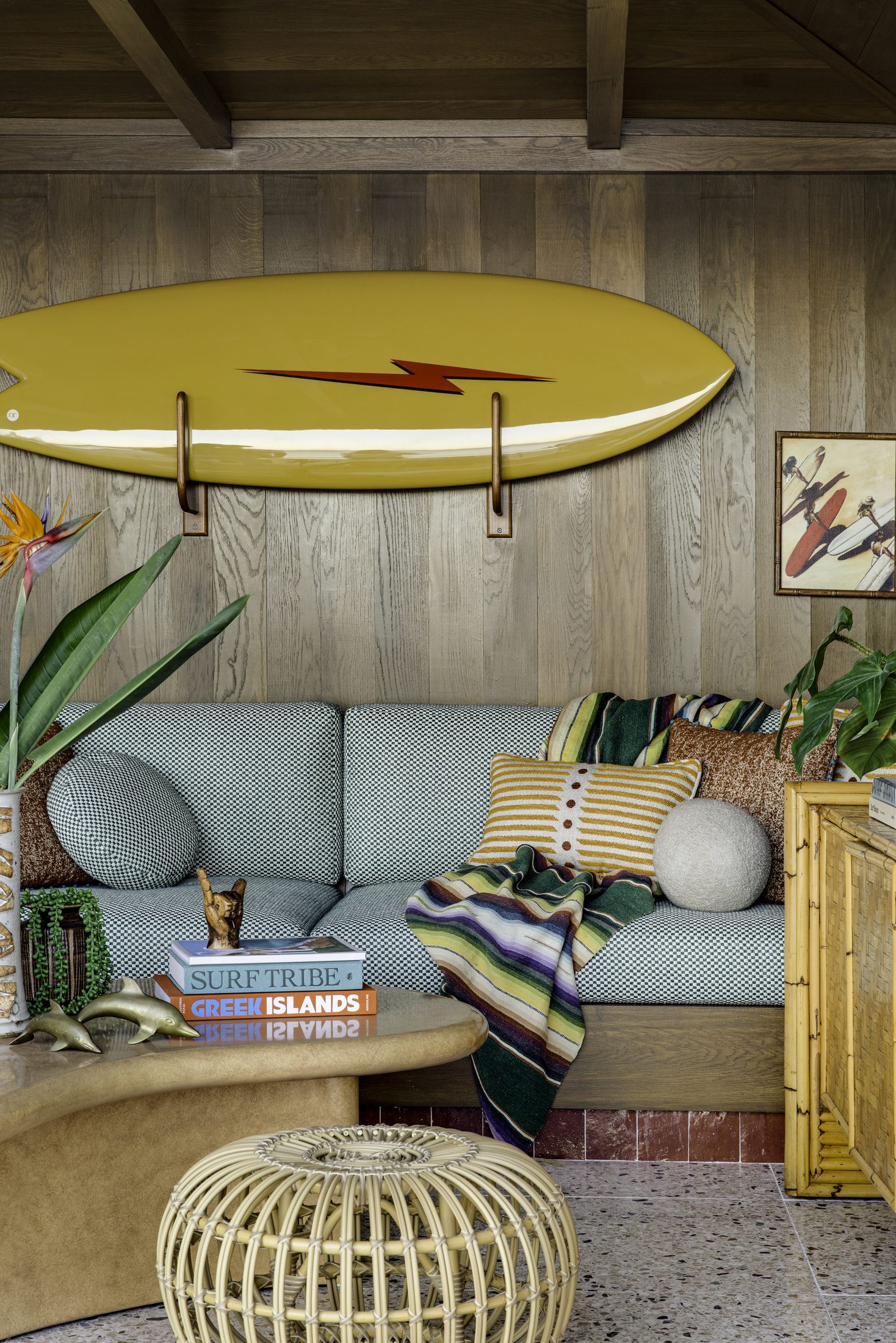 Yellow surfboard mounted above a built-in seating nook