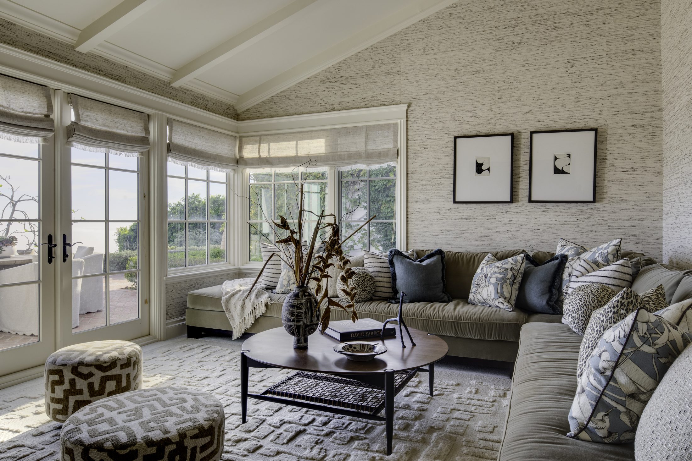 Sunroom with textured sectional, patterned ottomans, and garden light