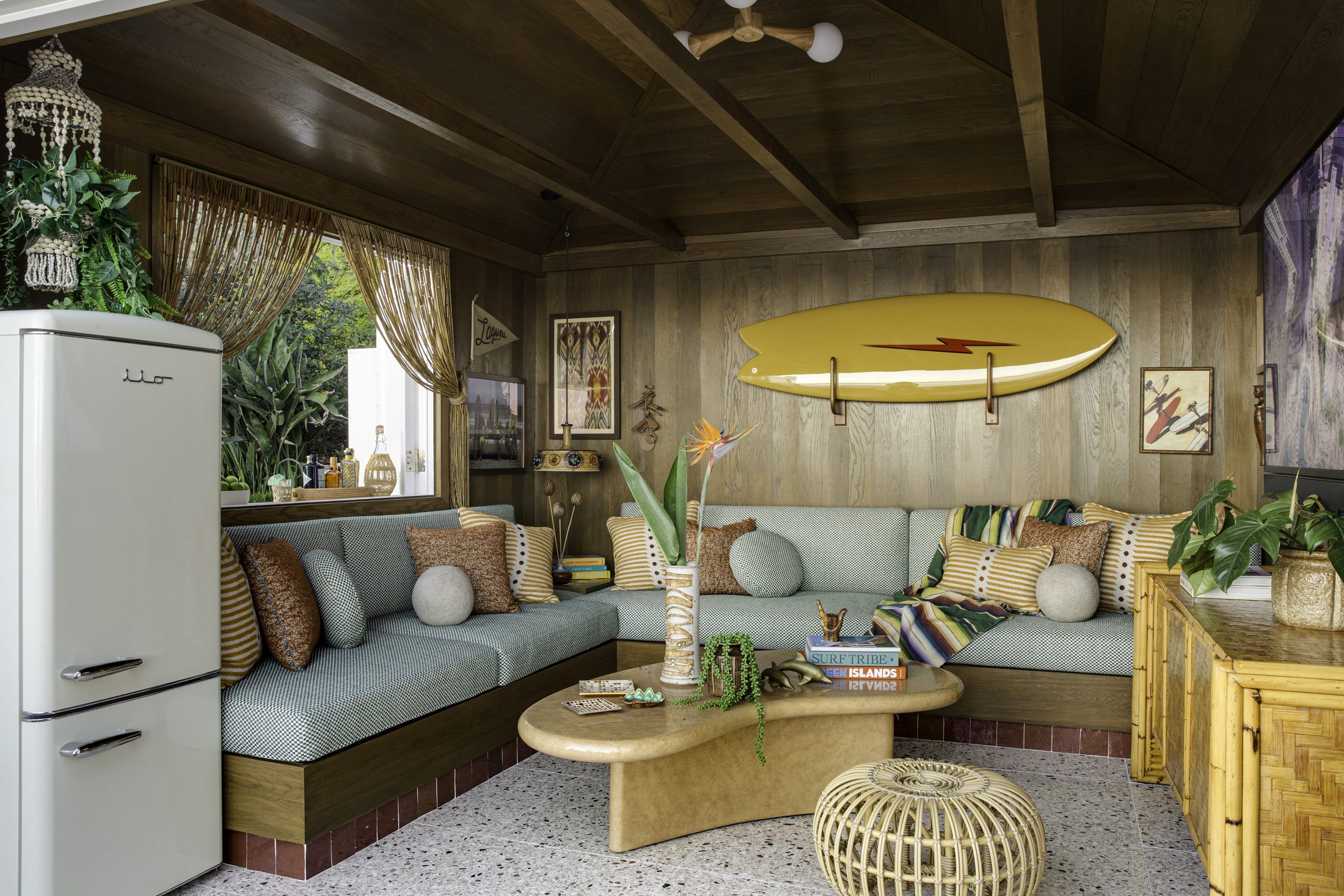 Cabana interior with sea-green banquette and vintage refrigerator