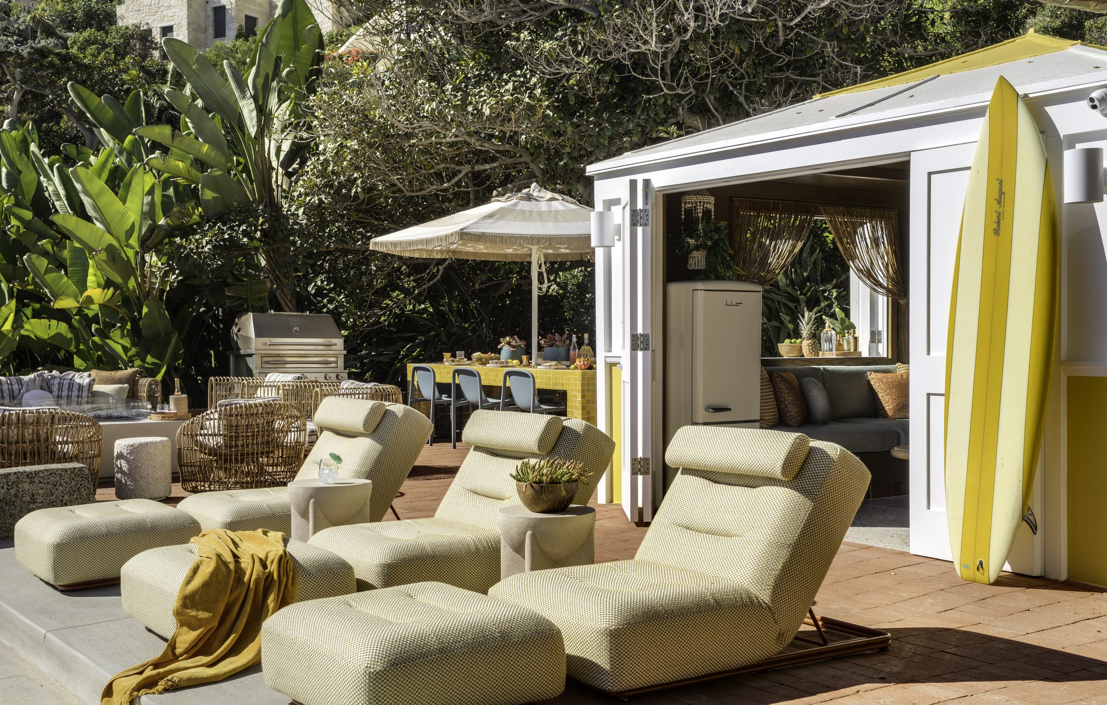 Sun loungers and surfboards outside the open cabana doors