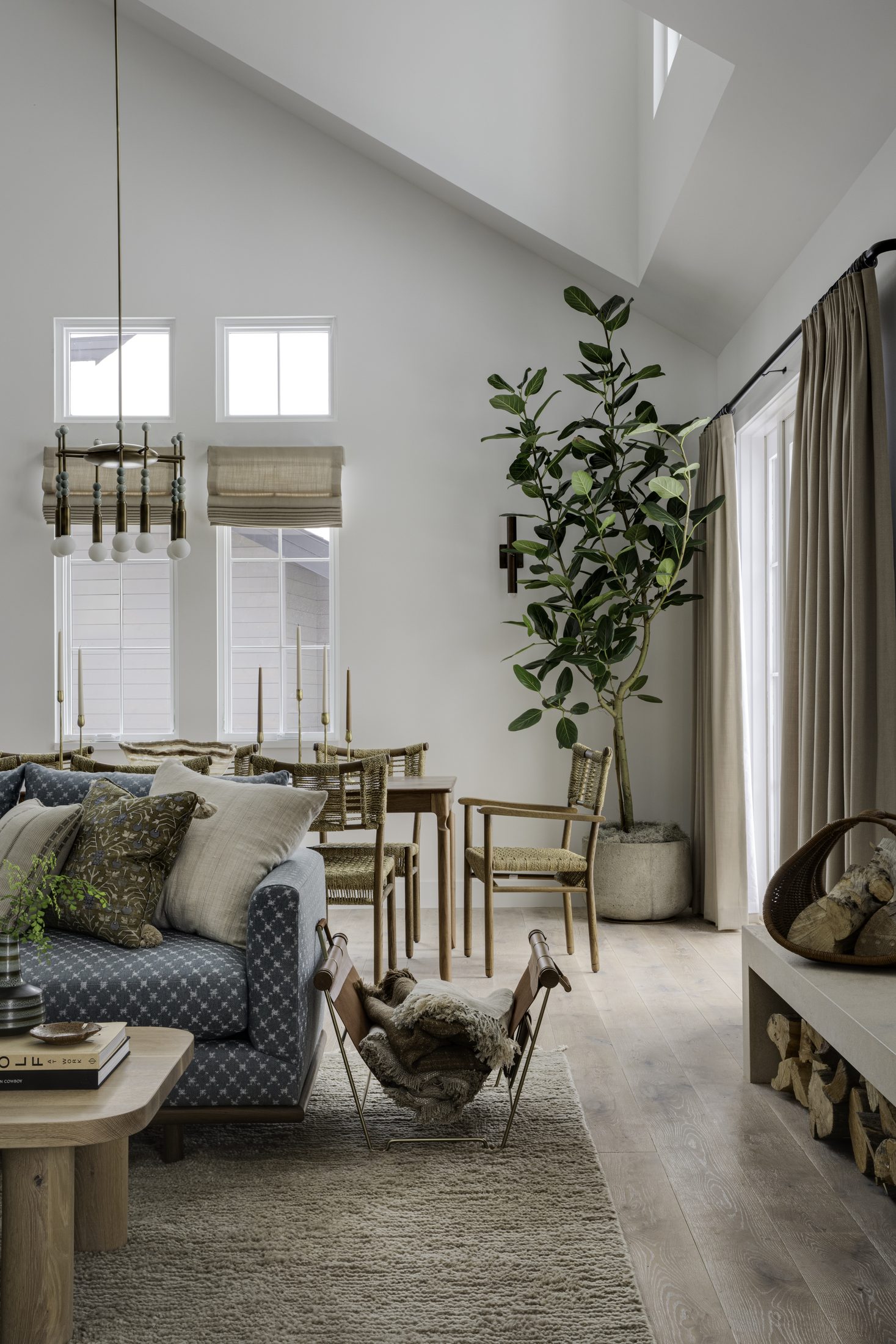 Vaulted living space with candlelit table and stacked firewood