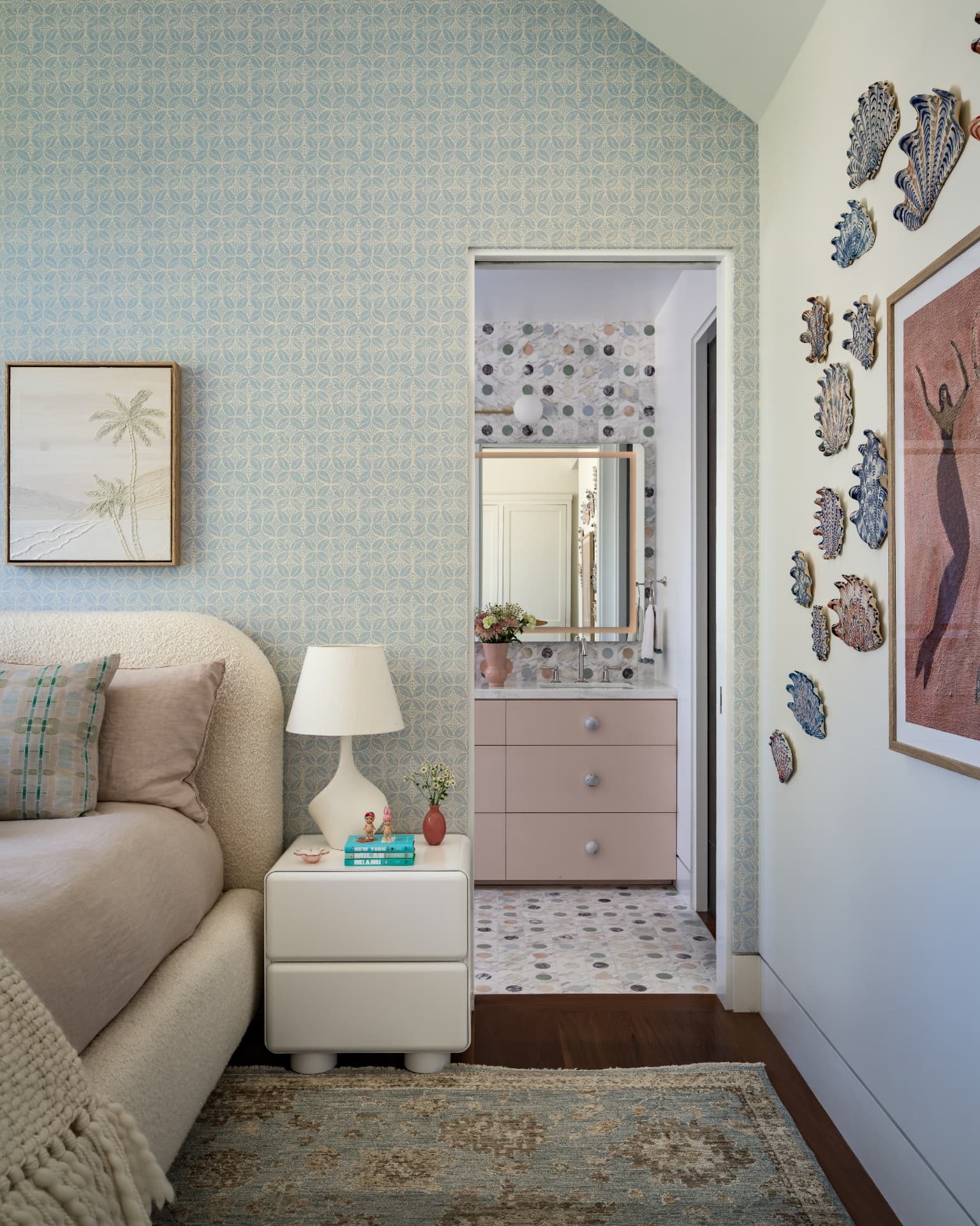 Bedroom vignette opening to the pink vanity beyond a shell wall