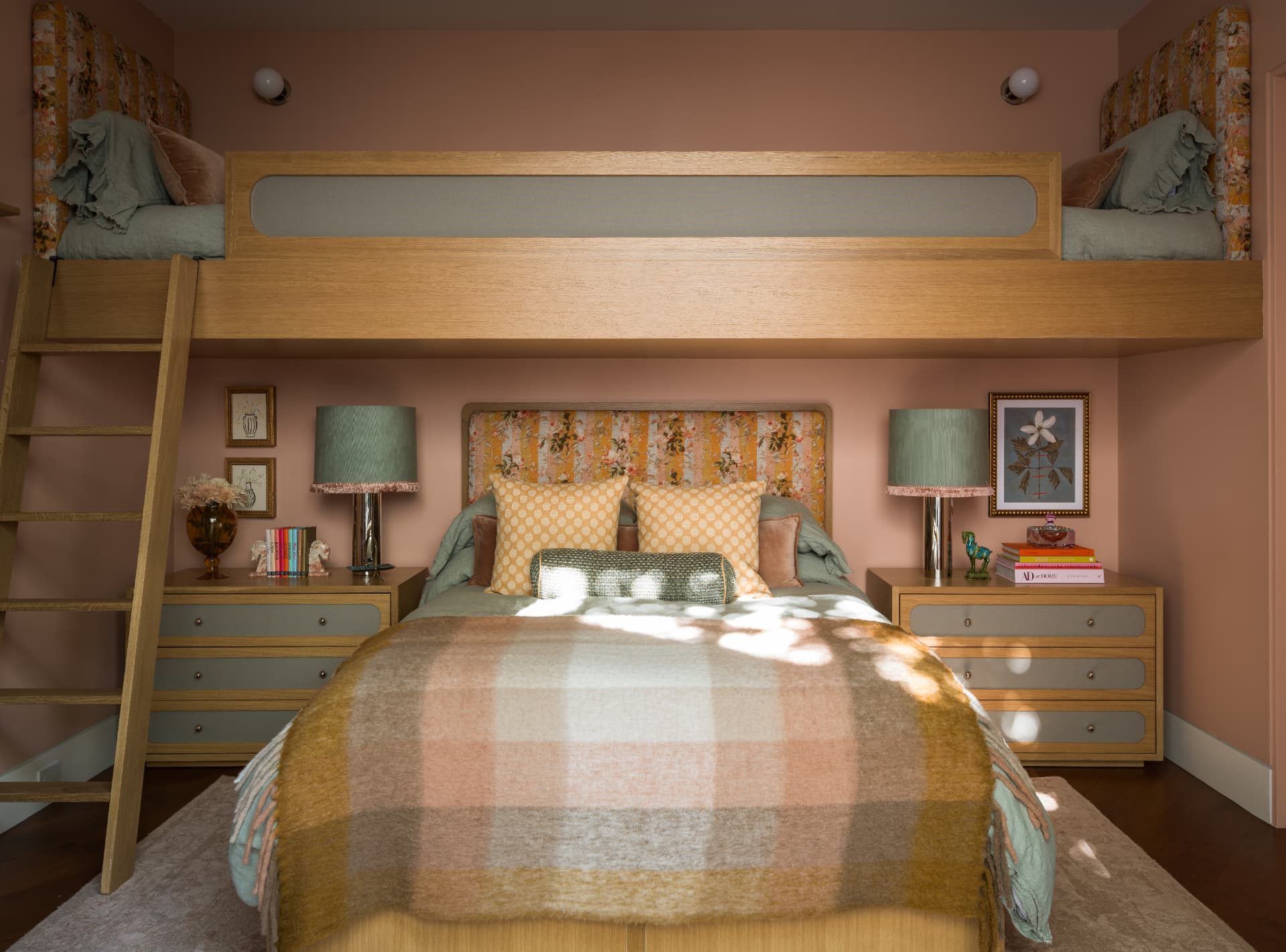 Pink bedroom with a lofted bunk, floral headboard, and sage lamps