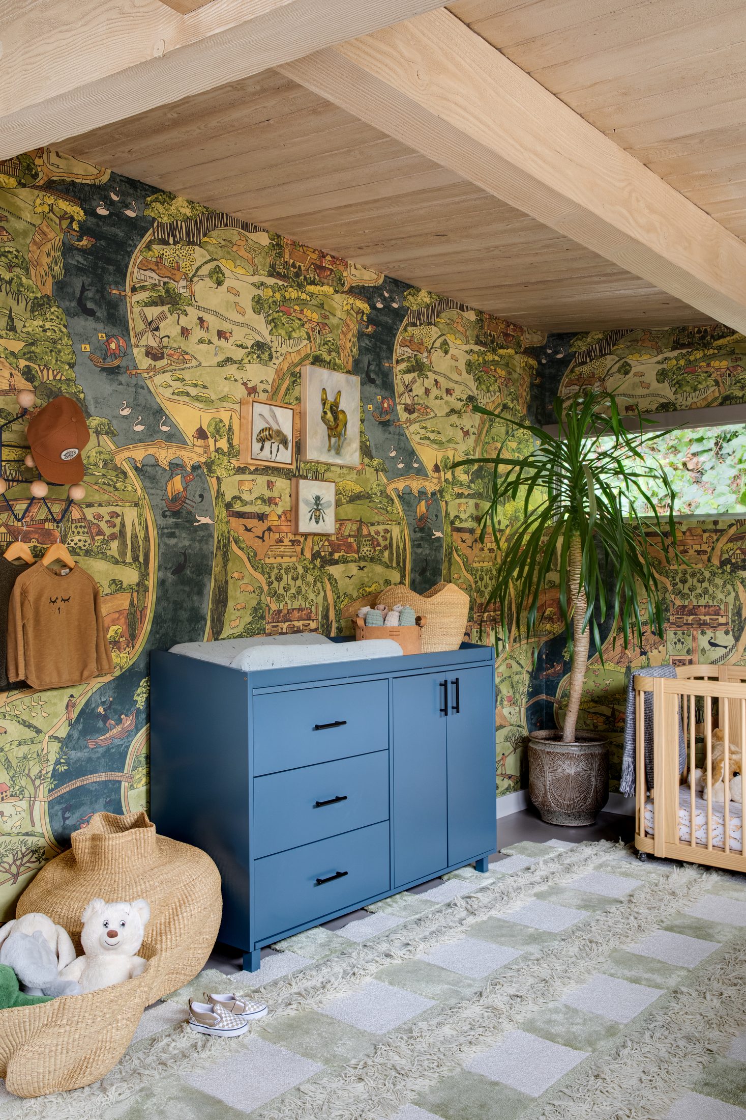 Nursery with hand-painted map mural and blue dresser