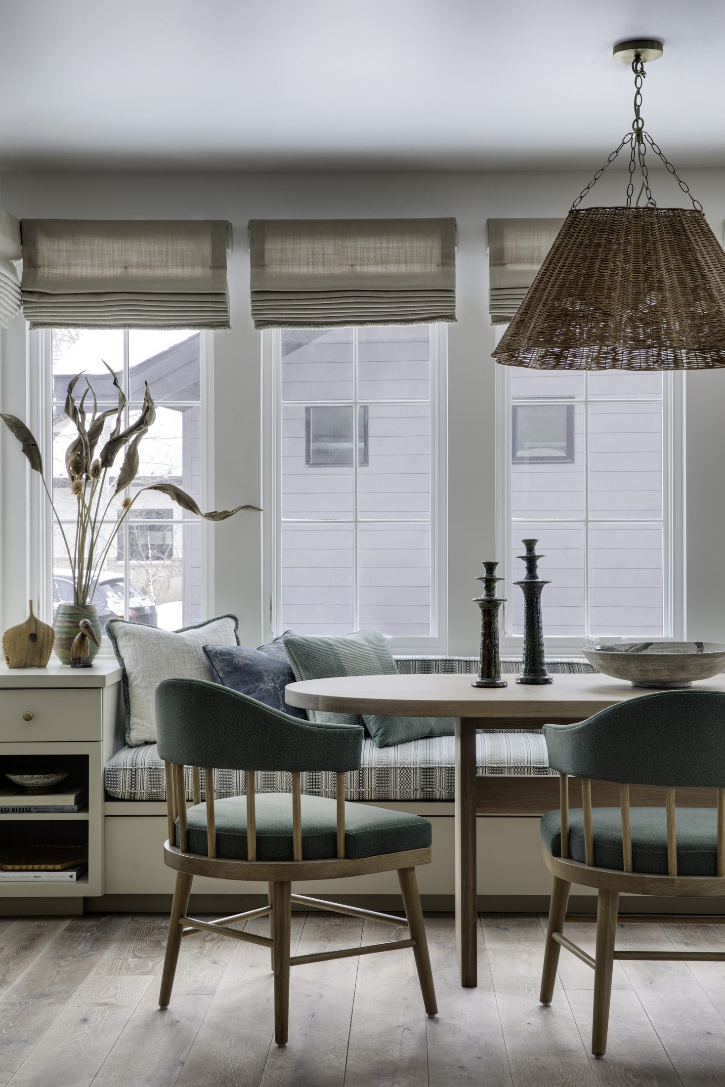 Banquette dining nook with woven pendant and snowy views