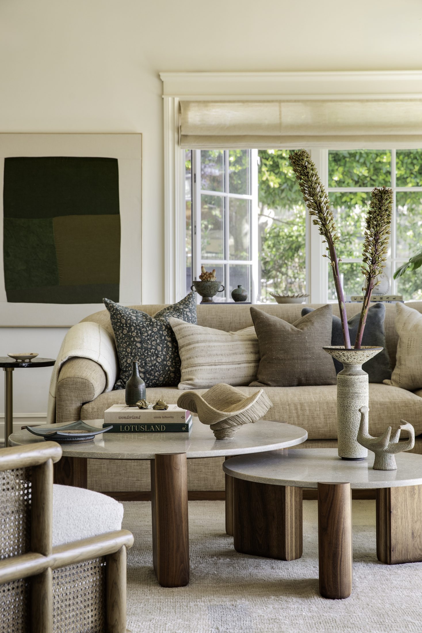 Living room with layered neutral upholstery and sculptural coffee tables