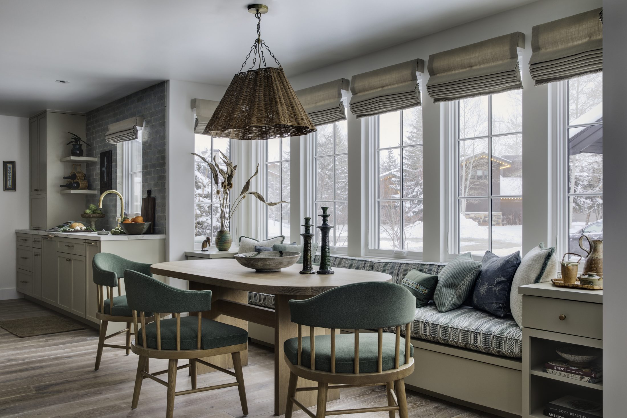 Kitchen banquette with green upholstered chairs and window seat