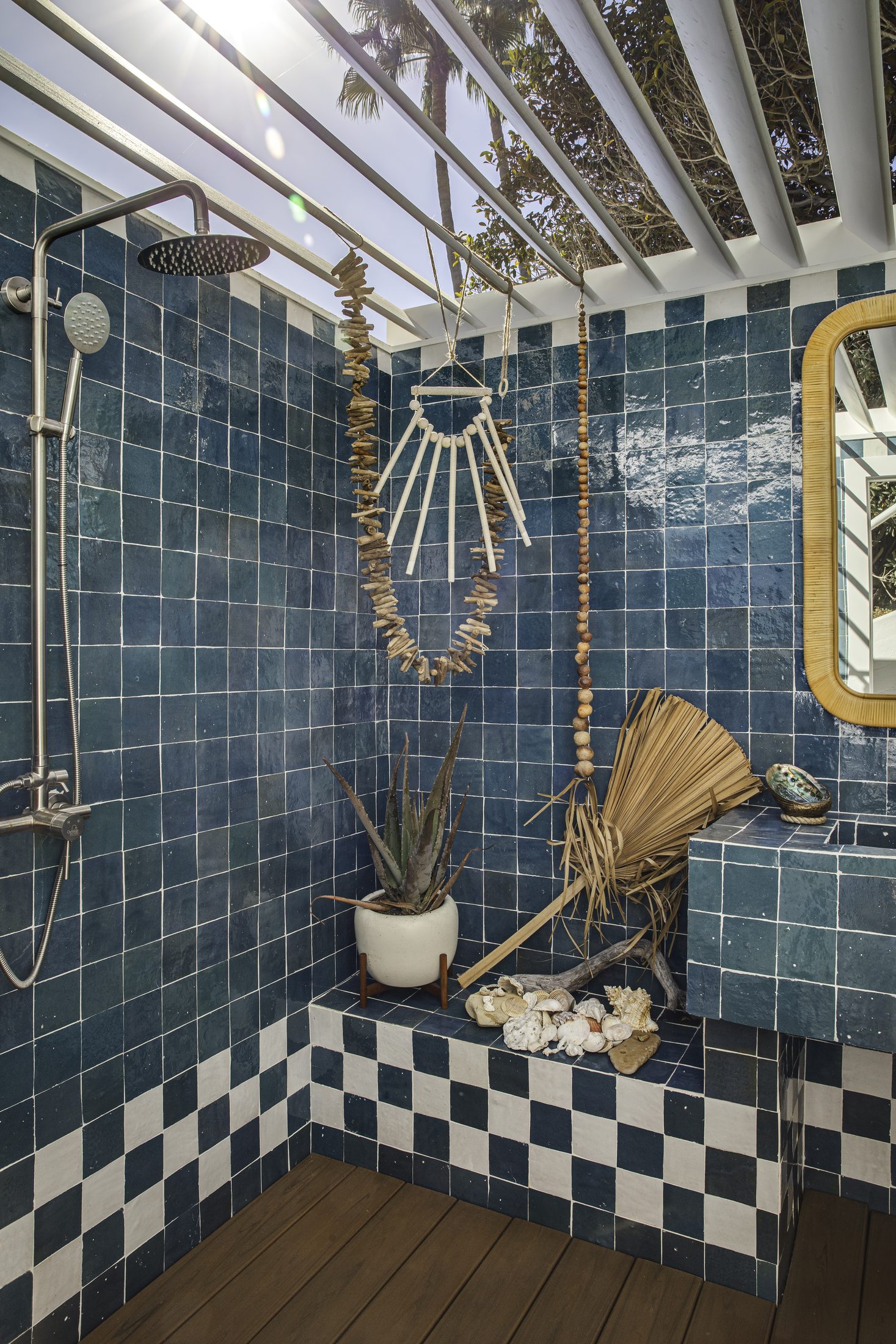 Outdoor shower clad in deep blue tile with checkered border